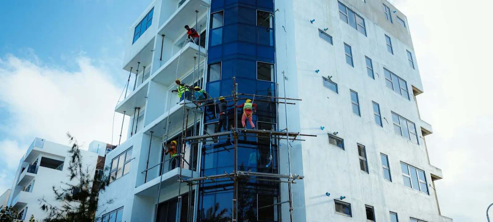 Workers on scaffolding repairing a condo building facade