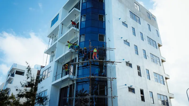 Workers on scaffolding repairing a condo building facade