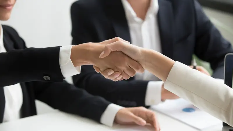 Board members shaking hands with a manager