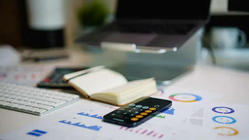Calculator and financial charts on a desk